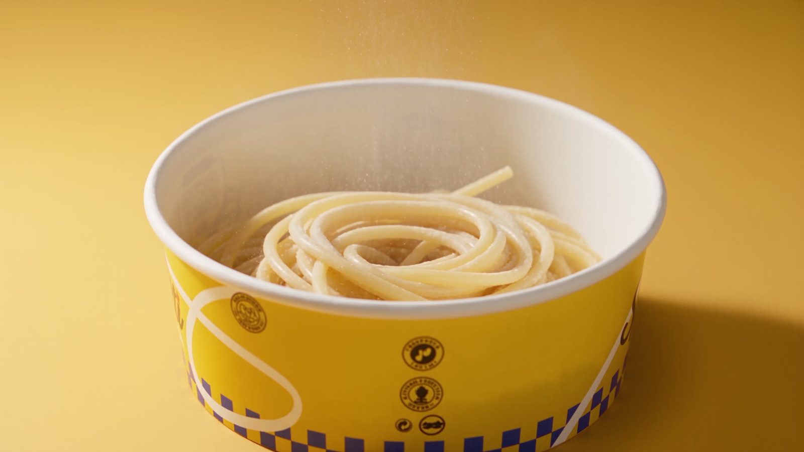 The yellow Casa Spaghetti bowl with a finished carbonara and rising steam