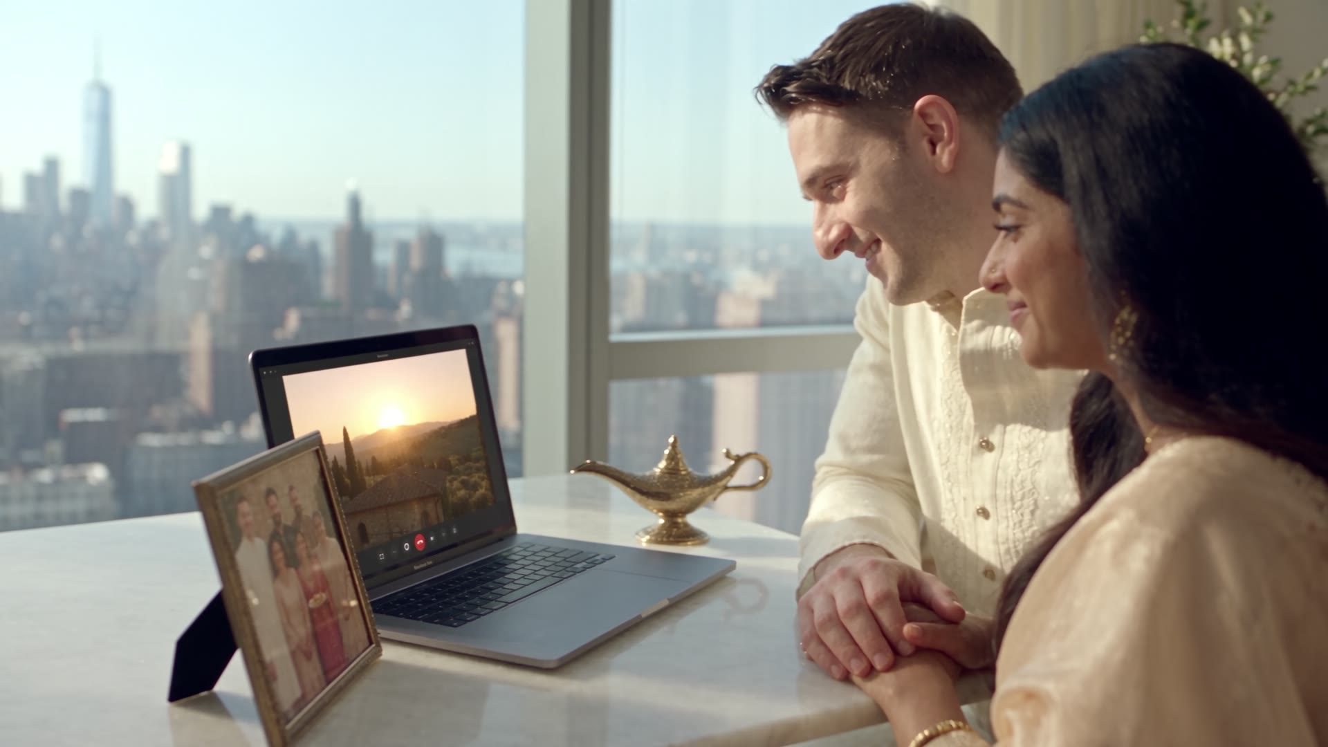 A couple at a computer with a Tuscan villa on the screen