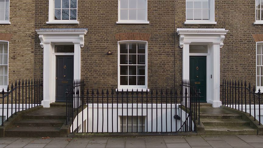 The facade of a London terraced house, brick and black doors
